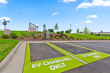 A parking lot with a green painted area that says "EV CHARGING ONLY".